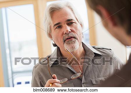 Serious Caucasian man holding eyeglasses View Large Photo Image Stock Photo - Serious Caucasian man holding eyeglasses. Fotosearch
