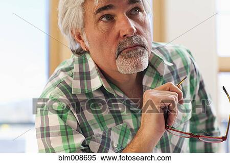 Serious Caucasian man holding eyeglasses View Large Photo Image Stock Photography - Serious Caucasian man holding eyeglasses. Fotosearch