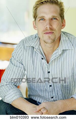 Stock Image - Serious Caucasian man with hands clasped. Fotosearch