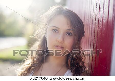 Stock Image - Serious Caucasian woman leaning on wall. Fotosearch