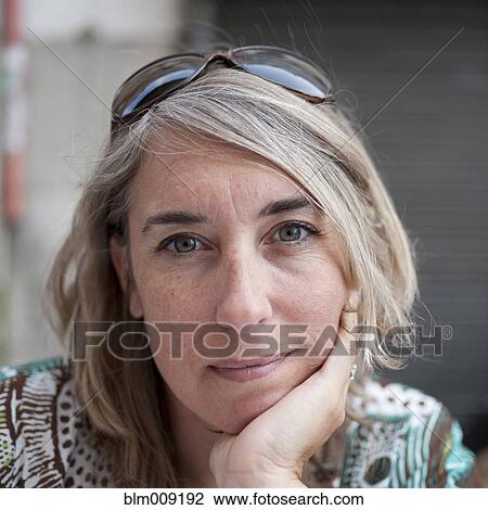 Stock Image - Serious Caucasian woman with head in hands. Fotosearch