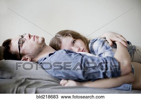 Serious couple hugging on bed View Large Photo Image Stock Image - Serious couple hugging on bed. Fotosearch