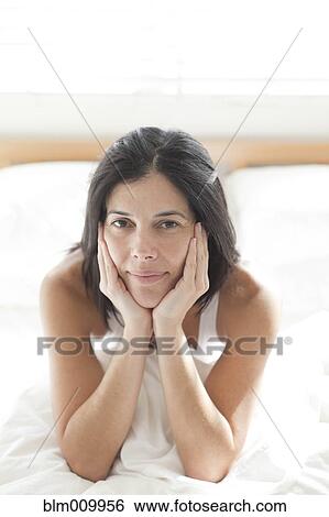 Serious Hispanic woman sitting in bed View Large Photo Image Stock Photograph - Serious Hispanic woman sitting in bed. Fotosearch