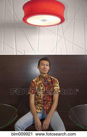 Serious Malaysian man sitting in cafe View Large Photo Image Stock Image - Serious Malaysian man sitting in cafe. Fotosearch