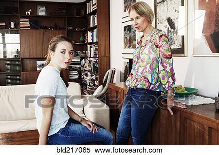 Serious mother and daughter in living room View Large Photo Image Stock Photography - Serious mother and daughter in living room. Fotosearch