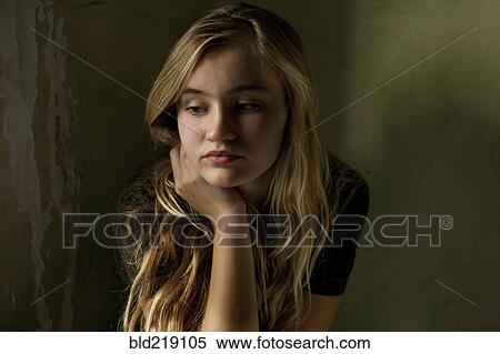 Stock Photography - Serious teenage girl sitting by window. Fotosearch