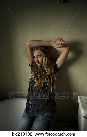 Serious teenage girl sitting in bathroom View Large Photo Image Stock Image - Serious teenage girl sitting in bathroom. Fotosearch