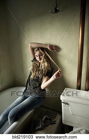 Serious teenage girl sitting in bathroom View Large Photo Image Stock Image - Serious teenage girl sitting in bathroom. Fotosearch