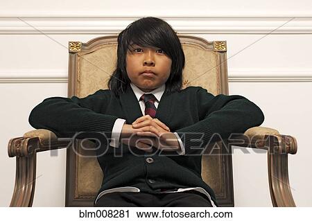 Serious Vietnamese boy sitting on elegant chair View Large Photo Image Stock Image - Serious Vietnamese boy sitting on elegant chair. Fotosearch