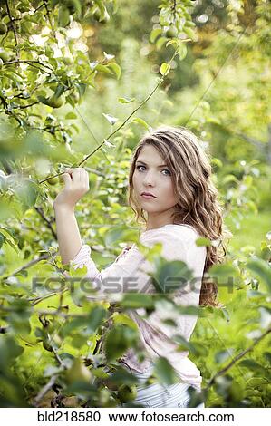 Serious woman examining plants in rural field View Large Photo Image Stock Image - Serious woman examining plants in rural field. Fotosearch