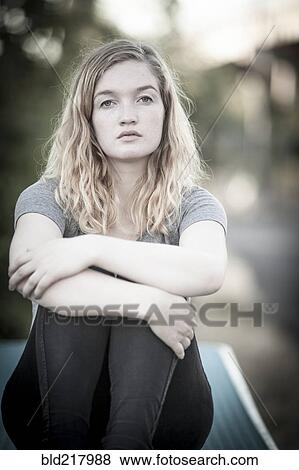 Serious woman hugging her knees View Large Photo Image Stock Photo - Serious woman hugging her knees. Fotosearch