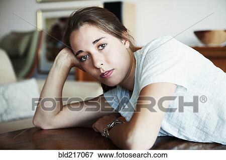 Serious woman leaning on table View Large Photo Image Stock Photo - Serious woman leaning on table. Fotosearch