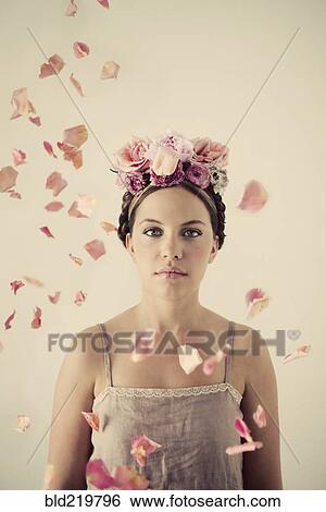 Stock Photograph - Serious woman wearing flowers in her hair. Fotosearch