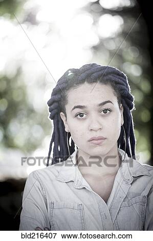 Stock Photo - Serious woman with dreadlocks outdoors. Fotosearch