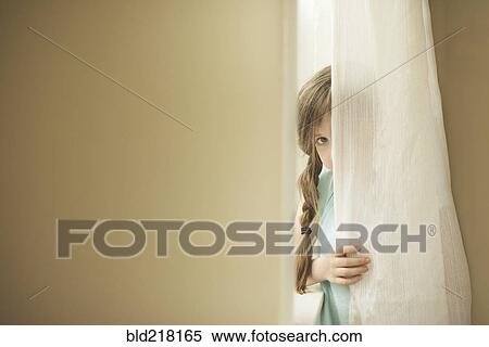 Shy Caucasian girl peeking around curtain View Large Photo Image Stock Photography - Shy Caucasian girl peeking around curtain. Fotosearch