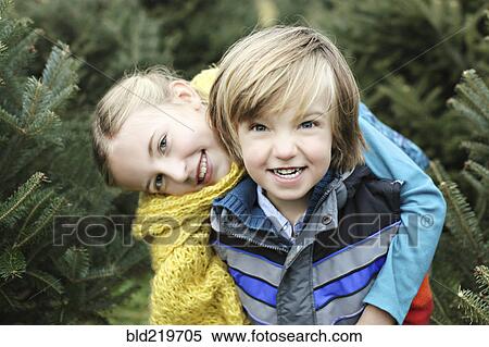 Stock Photography - Siblings hugging near pine trees. Fotosearch