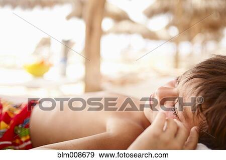 Sleeping mixed race boy laying on beach View Large Photo Image Stock Photo - Sleeping mixed race boy laying on beach. Fotosearch