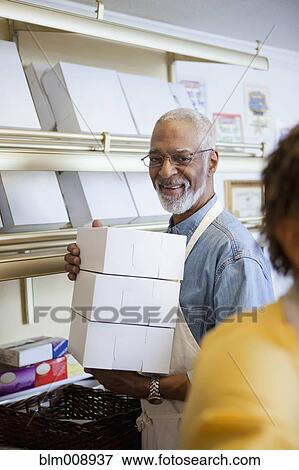 Small business owners working in bakery together View Large Photo Image Stock Photo - Small business owners working in bakery together. Fotosearch