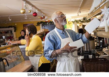 Stock Photo - Small business owners working in bakery together. Fotosearch