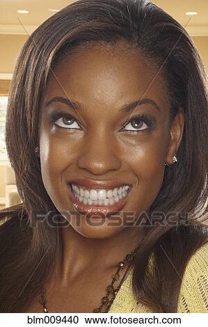 Stock Image - Smiling African American woman looking up. Fotosearch