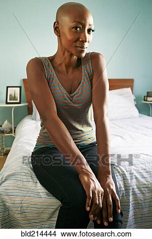 Smiling African American woman sitting on bed View Large Photo Image Picture - Smiling African American woman sitting on bed. Fotosearch