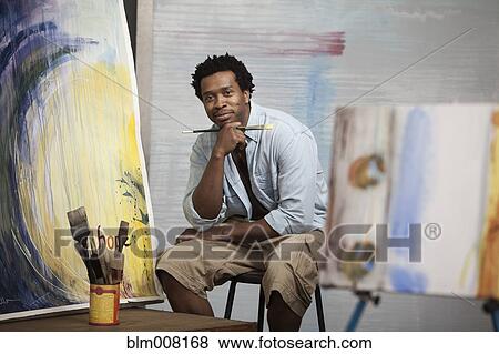 Smiling Black Artist sitting in studio View Large Photo Image Stock Photo - Smiling Black Artist sitting in studio. Fotosearch