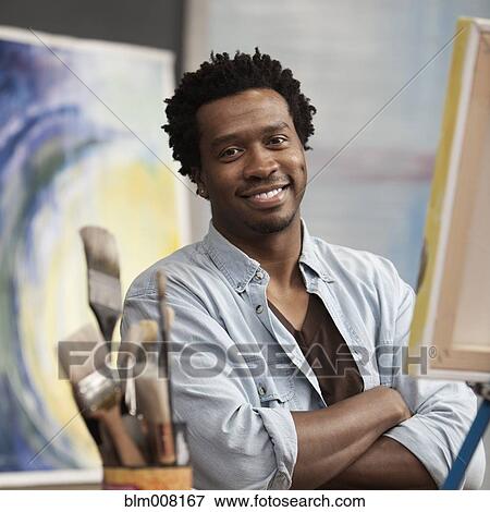 Stock Photo - Smiling Black artist with arms crossed. Fotosearch