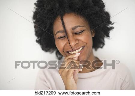 Stock Photo - Smiling Black woman playing with hair. Fotosearch