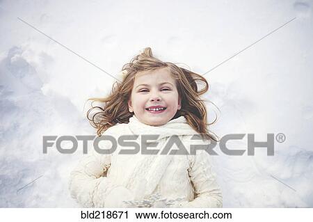 Smiling Caucasian girl laying in snow View Large Photo Image Stock Image - Smiling Caucasian girl laying in snow. Fotosearch