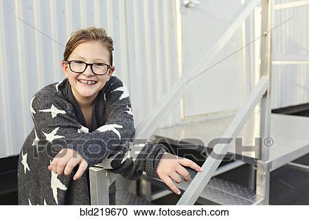 Stock Image - Smiling Caucasian girl standing outside trailer. Fotosearch