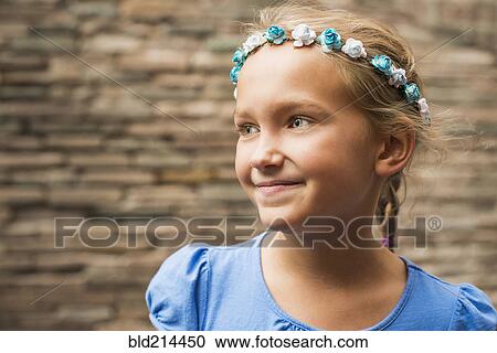 Stock Image - Smiling Caucasian girl wearing flower crown. Fotosearch