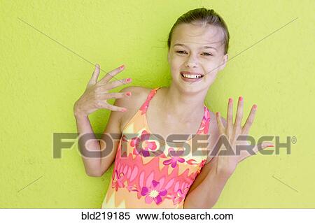 Stock Photography - Smiling Caucasian teenage girl displaying fingernails. Fotosearch