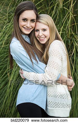 Stock Photo - Smiling Caucasian teenage girls hugging. Fotosearch