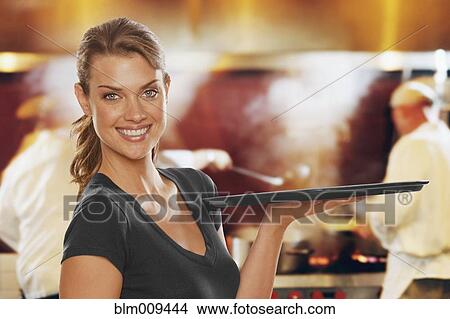 Smiling Caucasian waitress carrying tray View Large Photo Image Picture - Smiling Caucasian waitress carrying tray. Fotosearch