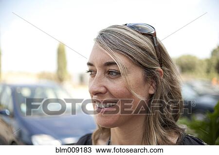 Stock Image - Smiling Caucasian woman standing outdoors. Fotosearch