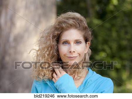 Stock Photograph - Smiling Caucasian woman standing outdoors. Fotosearch