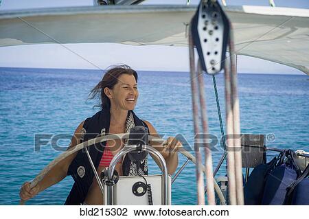 Smiling Caucasian woman steering boat View Large Photo Image Stock Image - Smiling Caucasian woman steering boat. Fotosearch