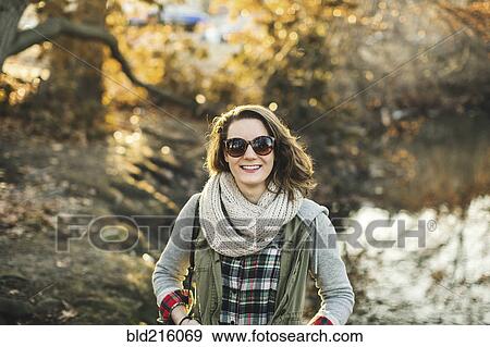 Stock Photo - Smiling Caucasian woman walking in park. Fotosearch