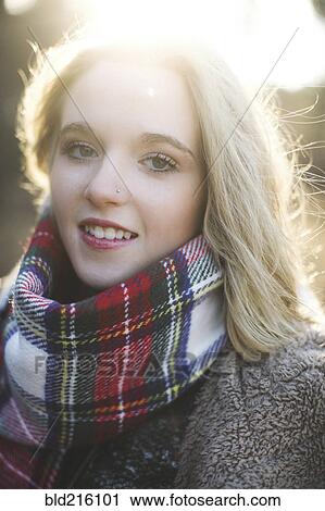 Stock Image - Smiling Caucasian woman wearing plaid scarf. Fotosearch