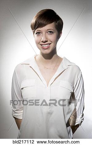 Stock Image - Smiling Caucasian woman wearing white shirt. Fotosearch
