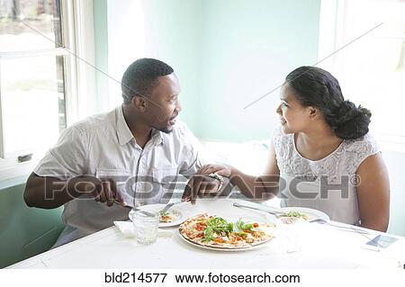 Smiling couple eating together at table View Large Photo Image Stock Photo - Smiling couple eating together at table. Fotosearch