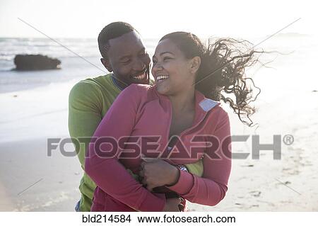 Smiling couple hugging on beach View Large Photo Image Picture - Smiling couple hugging on beach. Fotosearch