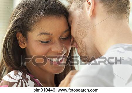 Stock Photograph - Smiling couple hugging outdoors. Fotosearch