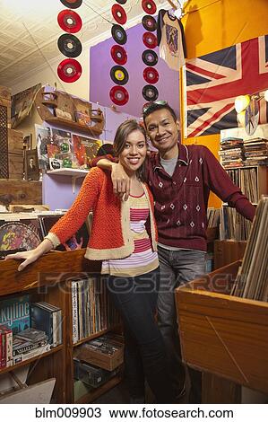 Smiling couple working in record store View Large Photo Image Stock Image - Smiling couple working in record store. Fotosearch