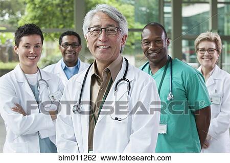 Stock Image - Smiling doctors standing together. Fotosearch