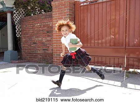 Smiling girl in school uniform running in driveway View Large Photo Image Stock Photography - Smiling girl in school uniform running in driveway. Fotosearch