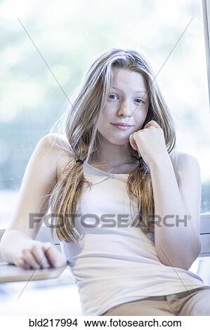 Picture - Smiling girl leaning on table. Fotosearch