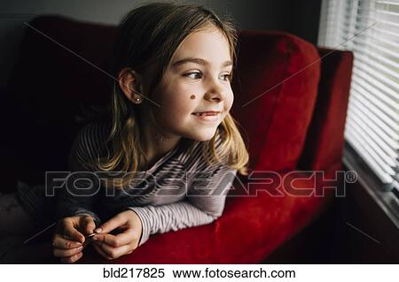 Smiling girl sitting in armchair View Large Photo Image Stock Photography - Smiling girl sitting in armchair. Fotosearch