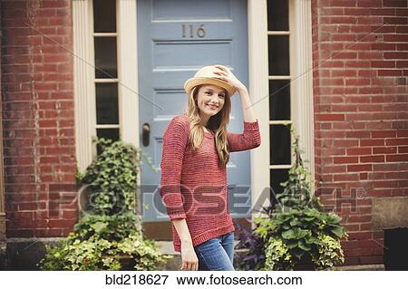 Stock Photo - Smiling girl standing near doorway. Fotosearch