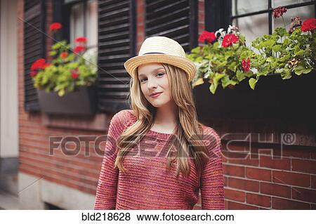 Stock Photo - Smiling girl standing outside house. Fotosearch